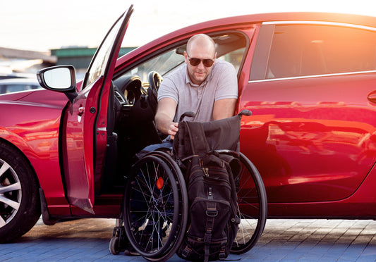 Young,Handicapped,Driver,Getting,In,Red,Car,Fom,Wheelchair